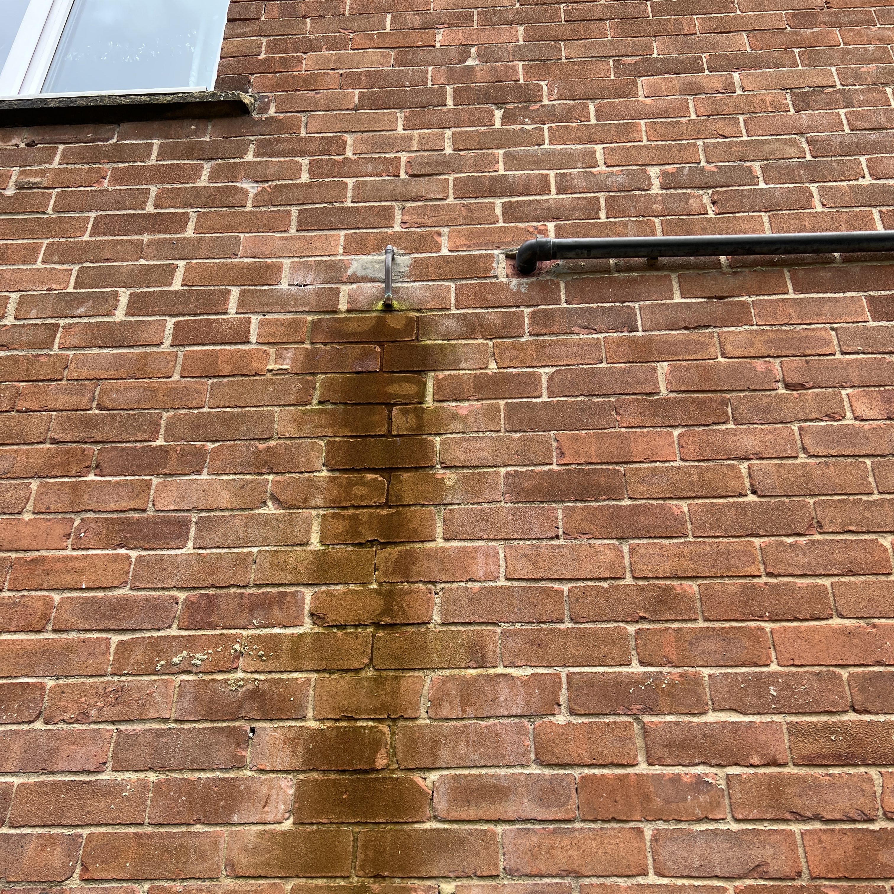 Water coming out of overflow from a metal pipe.